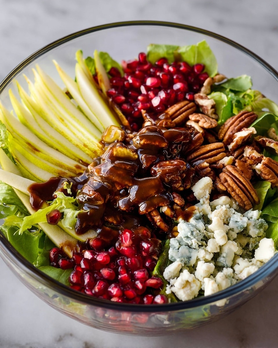 A clear glass bowl holds a layered salad set against a white marbled surface. The base layer is green leafy lettuce, partly hidden under toppings. On one side, there is a pile of bright red pomegranate seeds next to green lettuce leaves. Adjacent to that is a section with crumbly white-blue cheese pieces. Near the center, a cluster of glazed pecans with a shiny dark brown coating rests above the greens. On the left, thin slices of light green-yellow pear fan out neatly. The dark brown dressing drips over the pecans and cheese, adding a glossy texture. Photo taken with an iphone --ar 4:5 --v 7